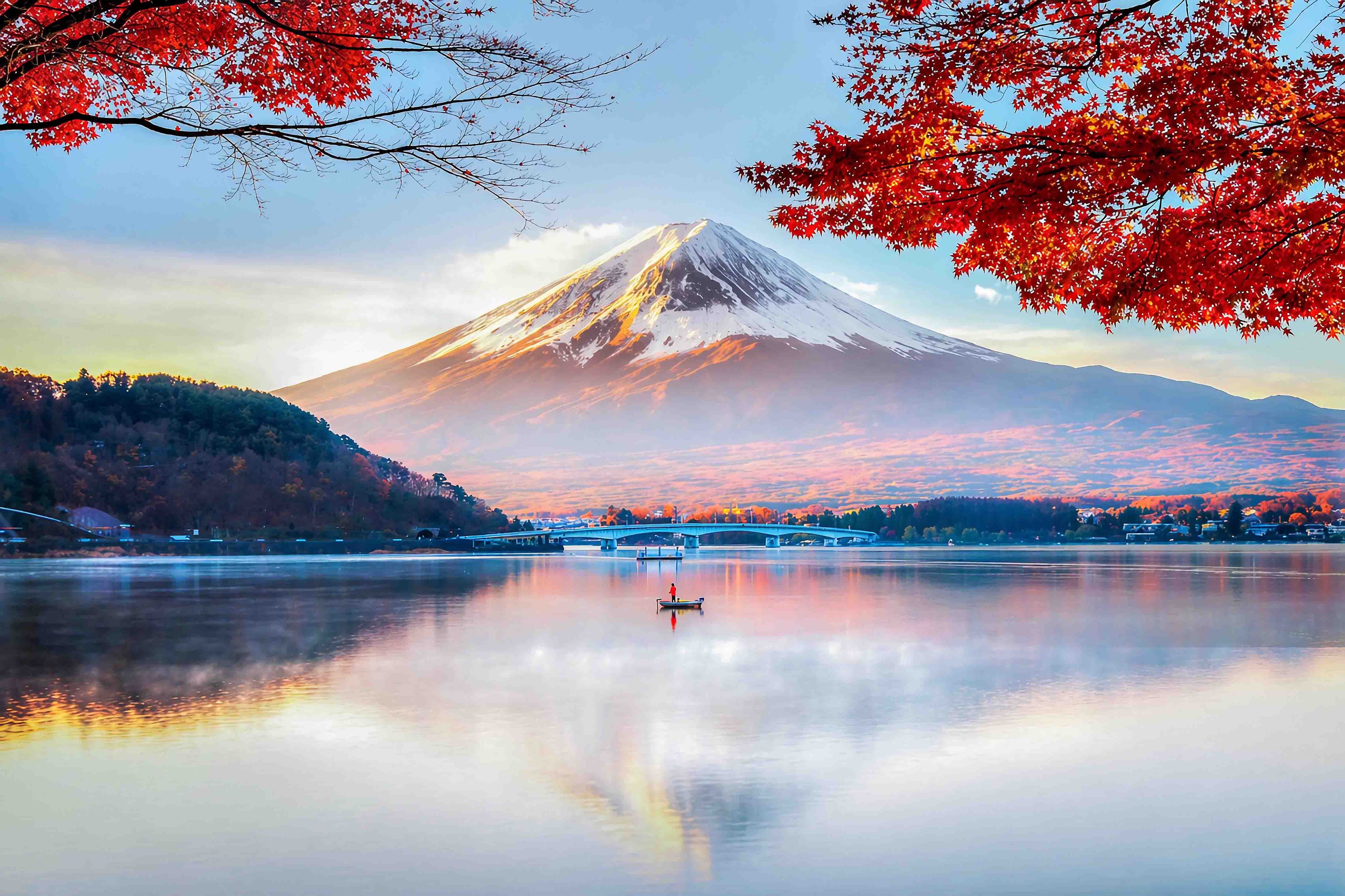 Mount Fuji with red autumn leaves and a lake in the foreground